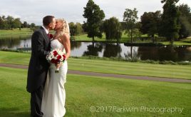 Bride and groom by lake at Brocket Hall