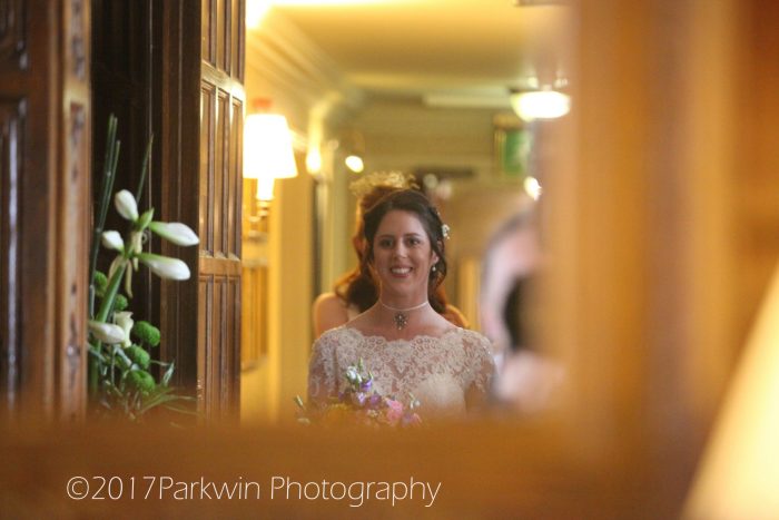 bride looking into mirror as she walks to wedding ceremony room Hanbury Manor